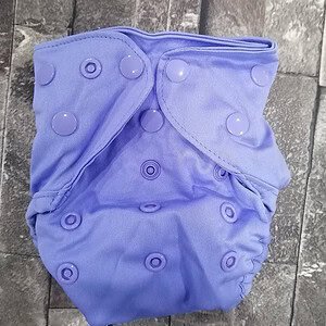 Soft purple cloth diaper with adjustable snaps for eco-friendly baby care.